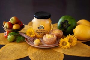 Bodegon gourmet con frasco de crema de limon Lemonella postres y frutas seleccionadas